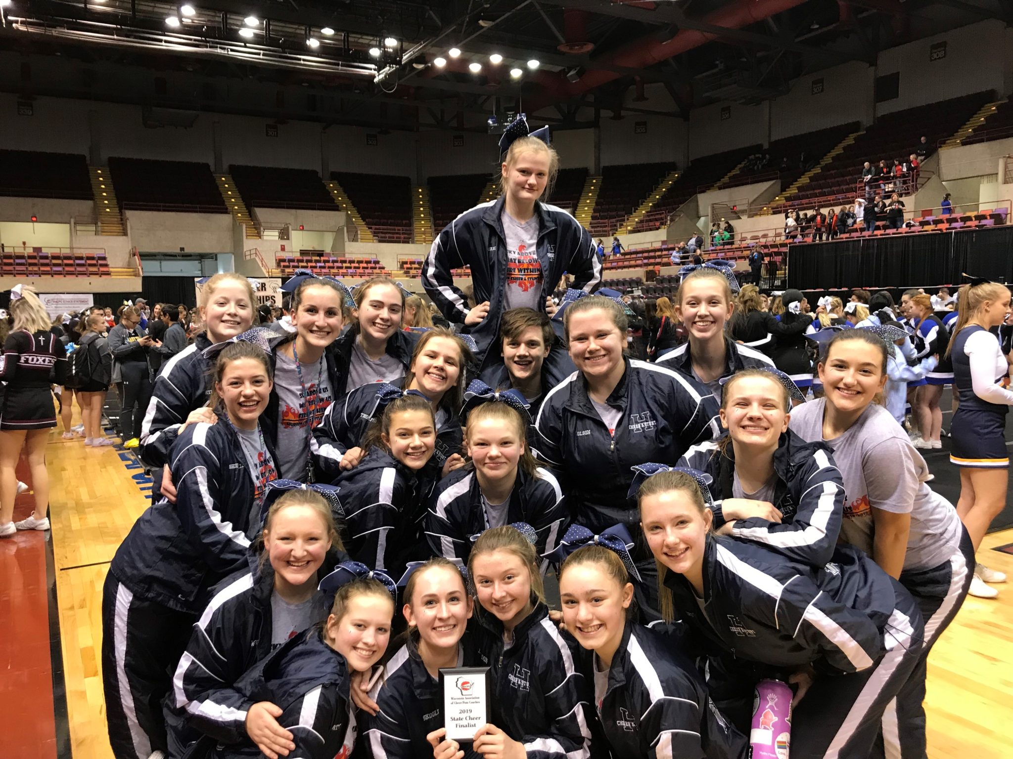 Cheer and stunt team pose with their 5th place win at state.