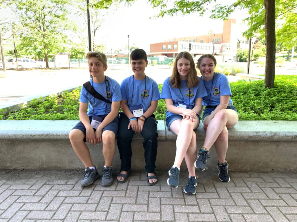 Hudson students taking a rest on a bench in the Hudson t-shirts.