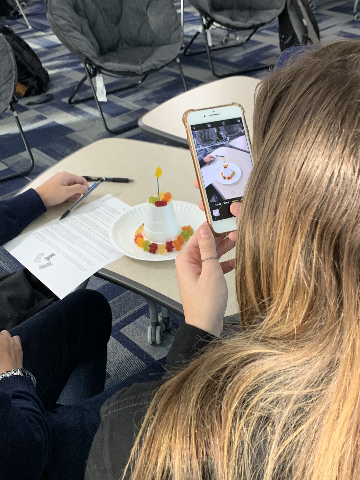 Students taking photos of their gummy bears.