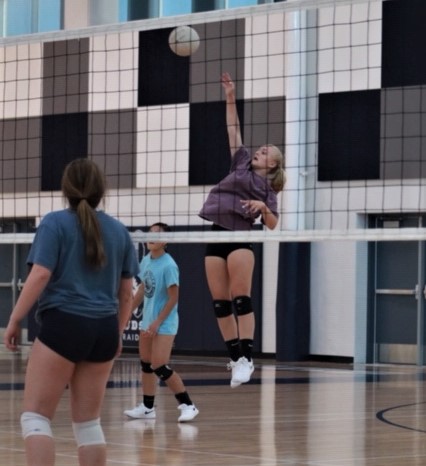 Volleyball player jumping high to block ball.
