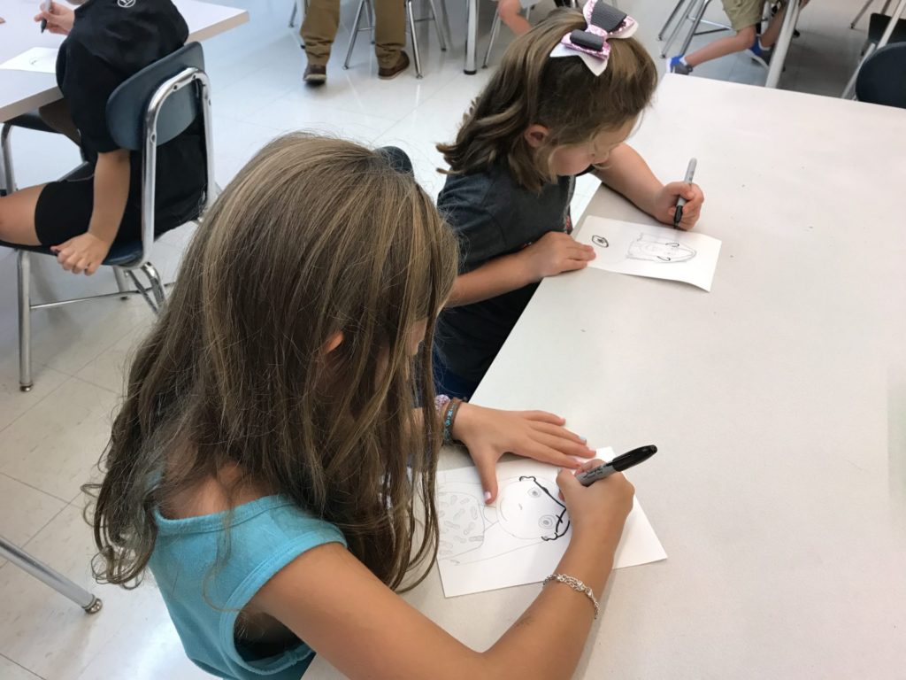 Two students drawing their self-portrait.