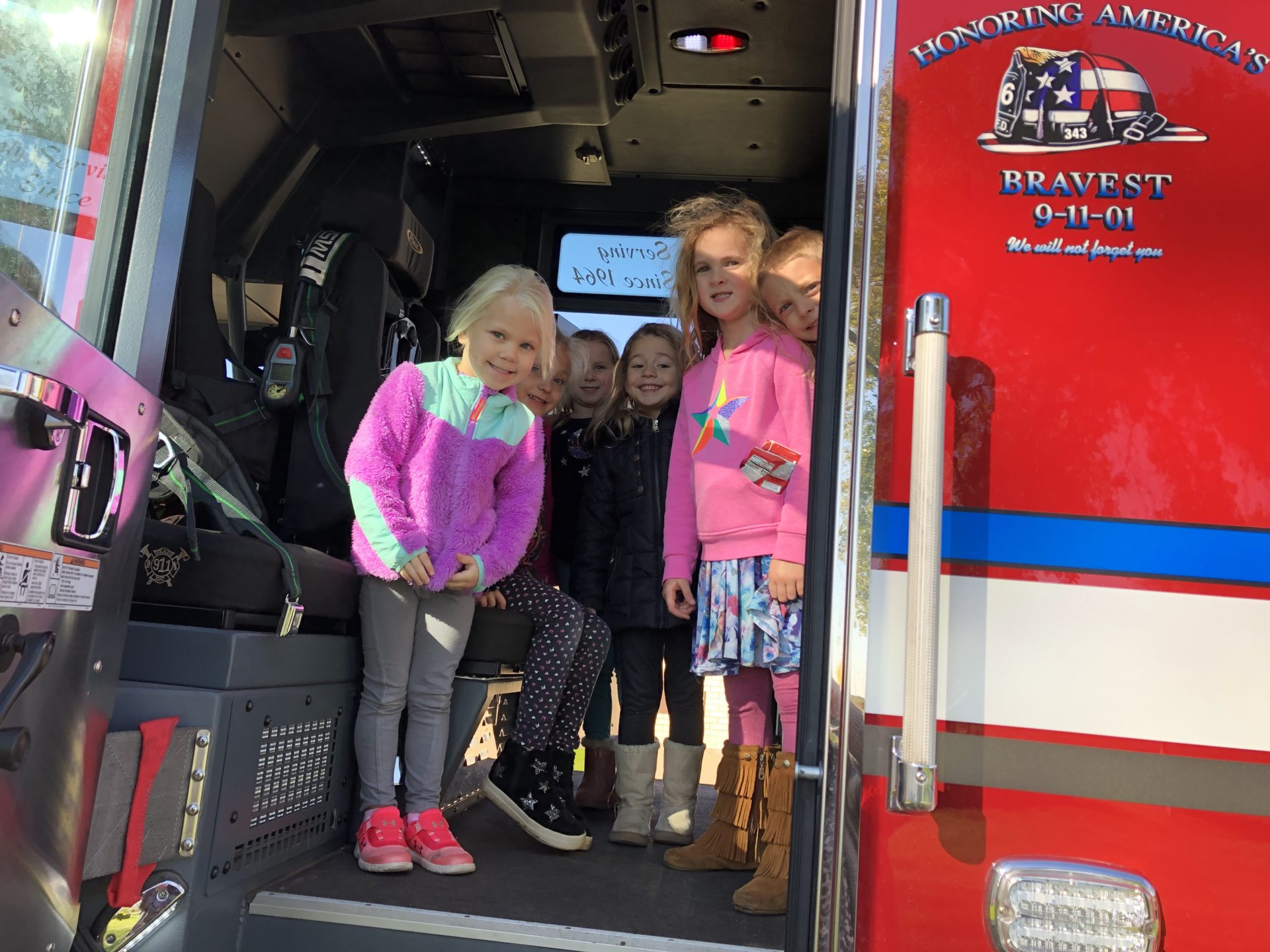 A group of children inside the fire truck.