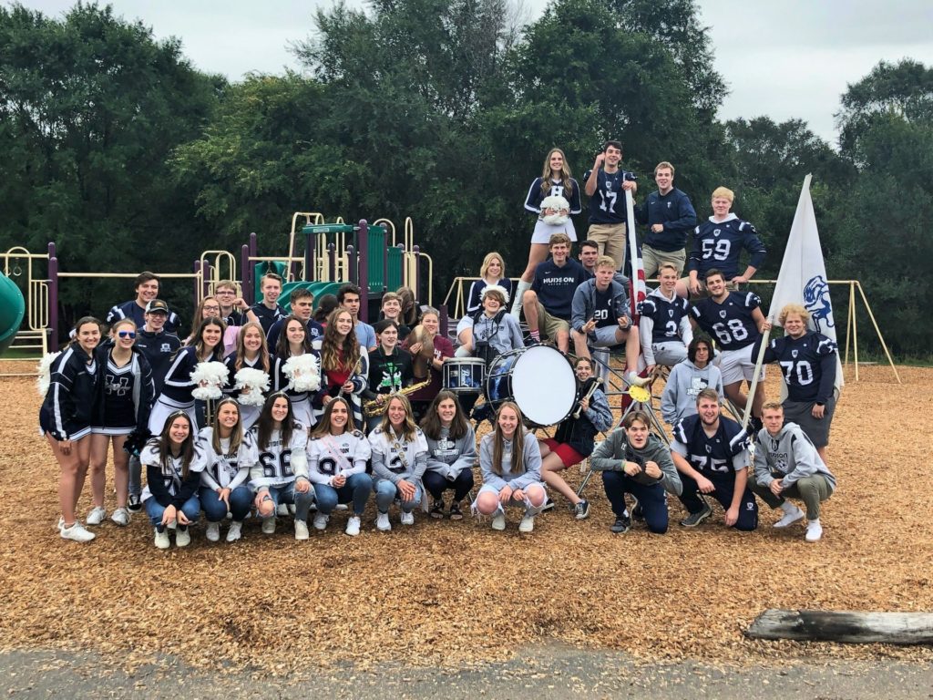 High school football players and Pep Band at elementary playground