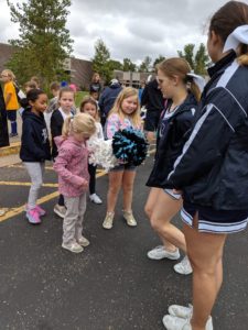 Elementary students meet high school football team, marching band and cheerleading squad members.