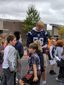 Elementary students meet high school football team players.