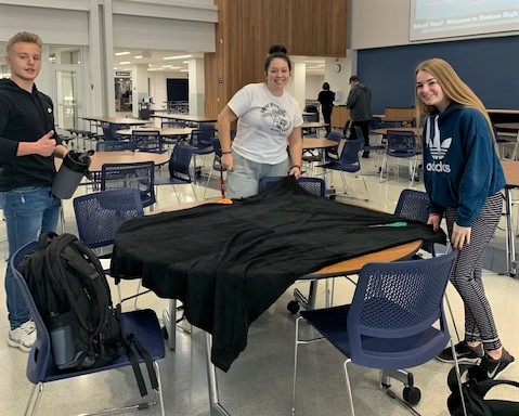 A group of students working on their blanket. 