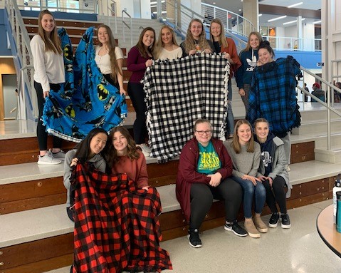 A group of students pose with their completed blankets.