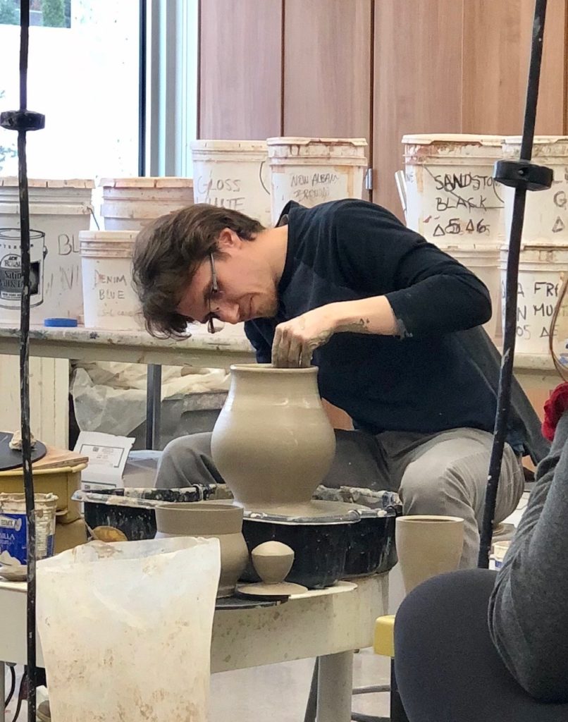 Dane Hodges, ceramic artist, working on a pot on the wheel.