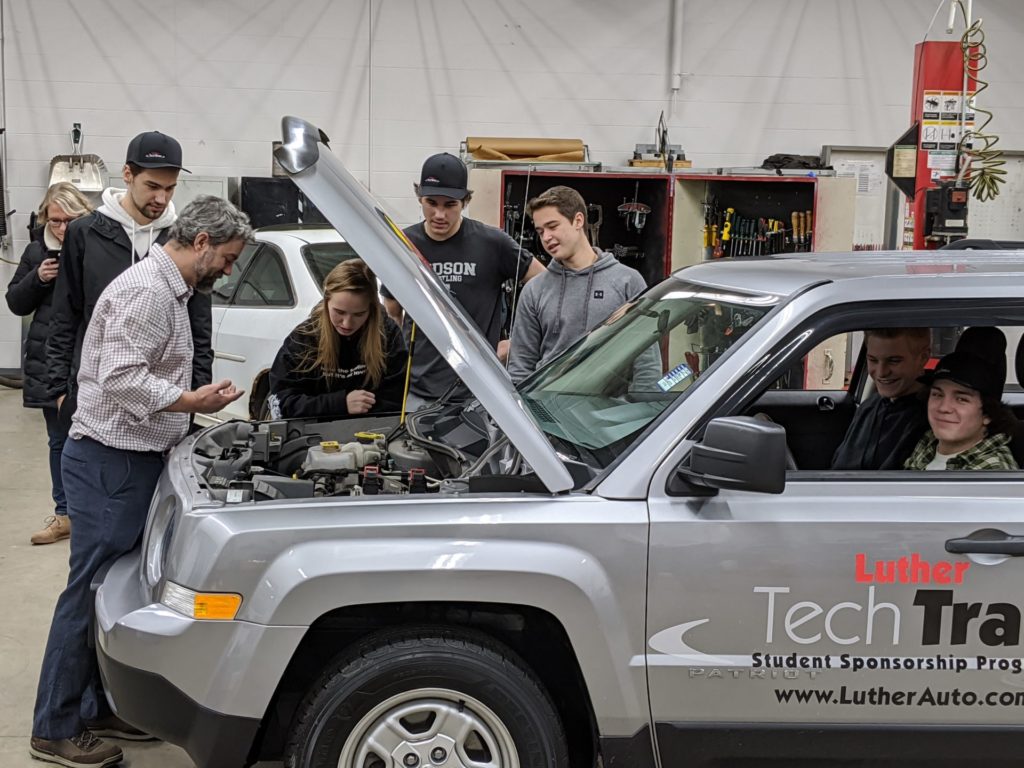 Students and their Tech Ed teacher are having a look under the hood of the new jeep.