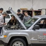 Students and their Tech Ed teacher are having a look under the hood of the new jeep.
