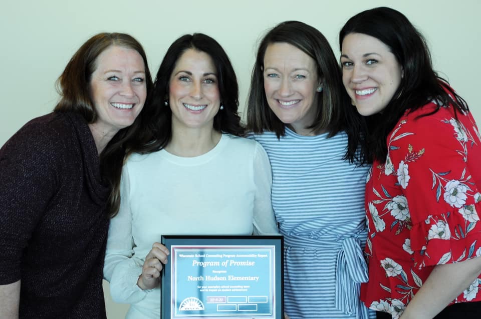 Four of the elementary counselors pose with the program of promise award.