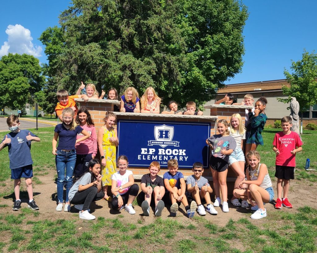 A group of students posing with the EP Rock sign in front of the school.