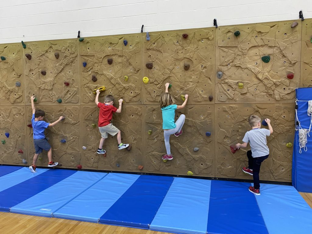 Students climbing the Climbing wall during PE class