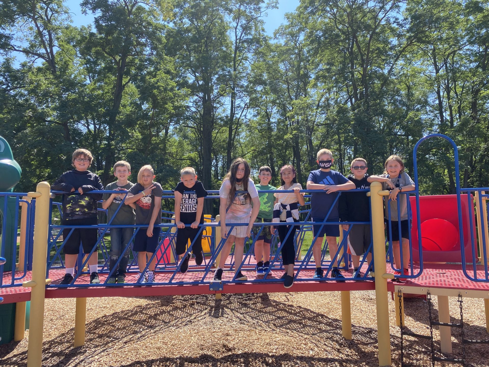 A group of students lined up on the playground bridge.