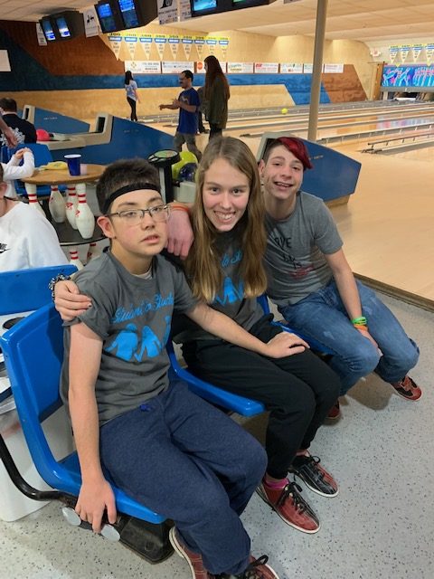 Students sitting at the bowling alley.