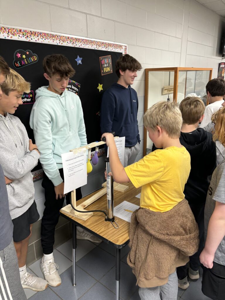 Students showing their projects in hallway display.