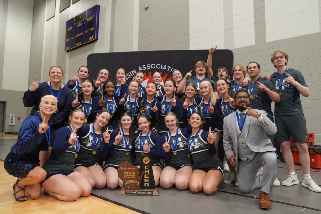 Cheer and stunt team pose with their championship trophy.